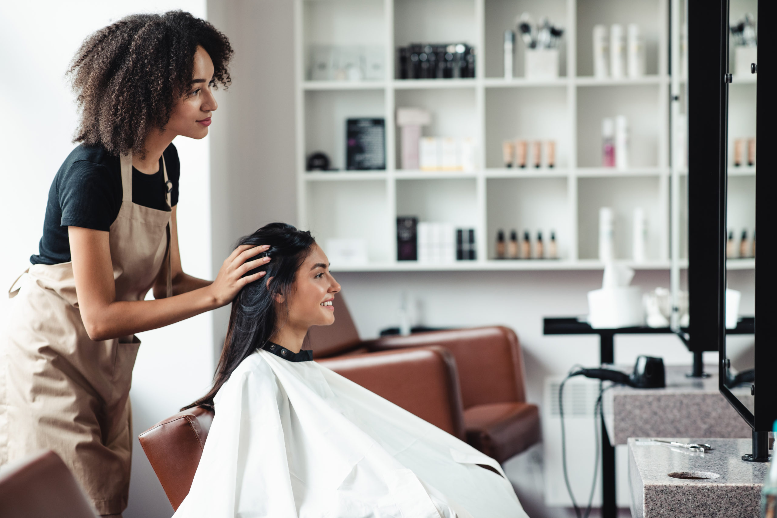 Young woman looking for changes, trying new hairstyle at beauty salon Young woman looking for changes, trying new hairstyle at beauty salon