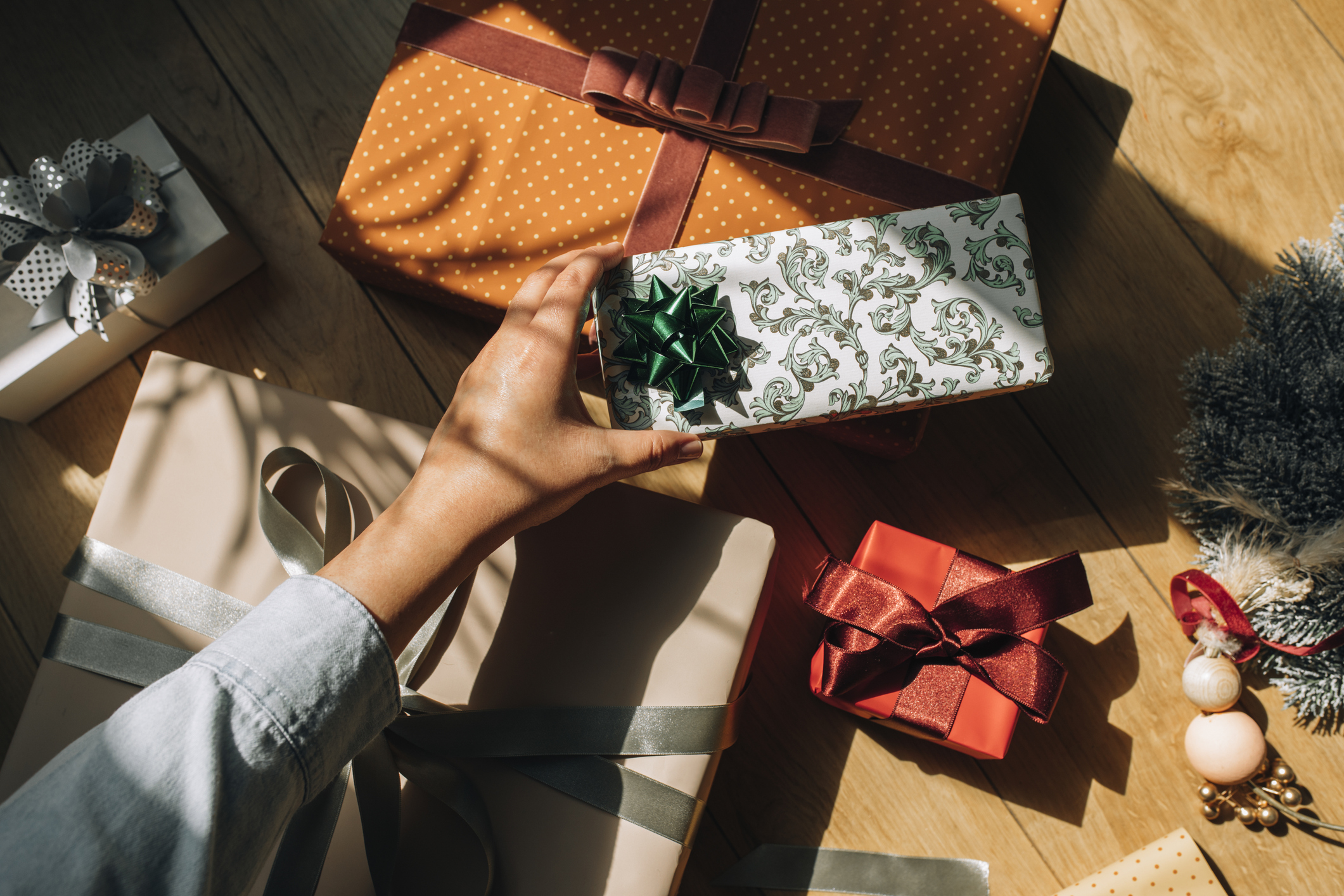 Hand of a Woman Holding a Wrapped Christmas Present, an Overhead View Hand of a Woman Holding a Wrapped Christmas Present, an Overhead View