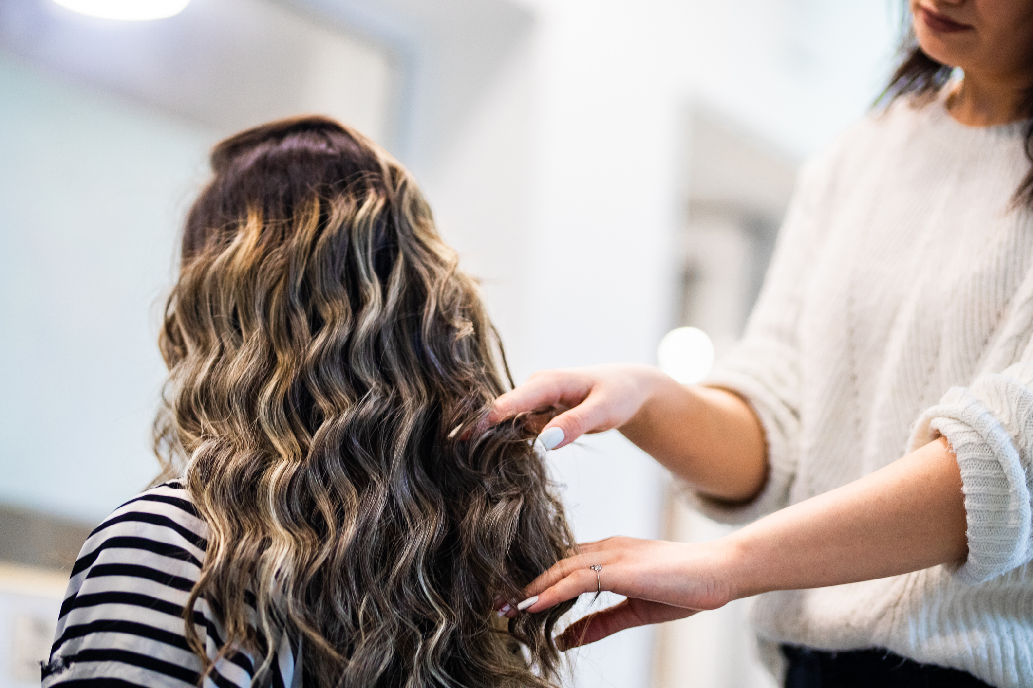 Women with beautiful long black hair at treatment in hairstylist salon Women with beautiful long black hair at treatment in hairstylist salon