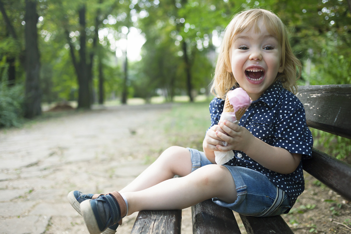 Little child eating ice cream in a park