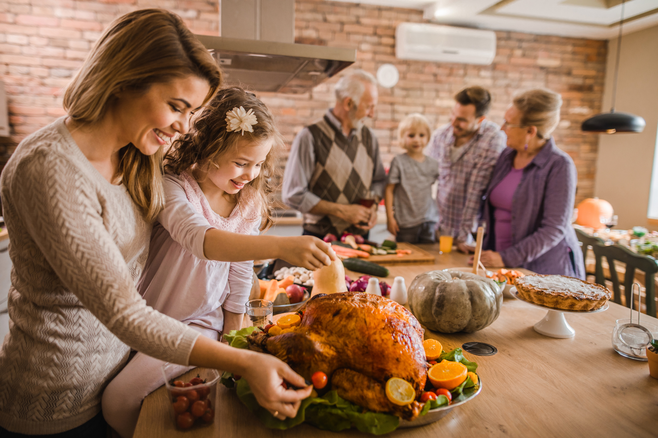 Happy mother and daughter preparing roasted turkey for Thanksgiving dinner. Happy mother and daughter preparing roasted turkey for Thanksgiving dinner.
