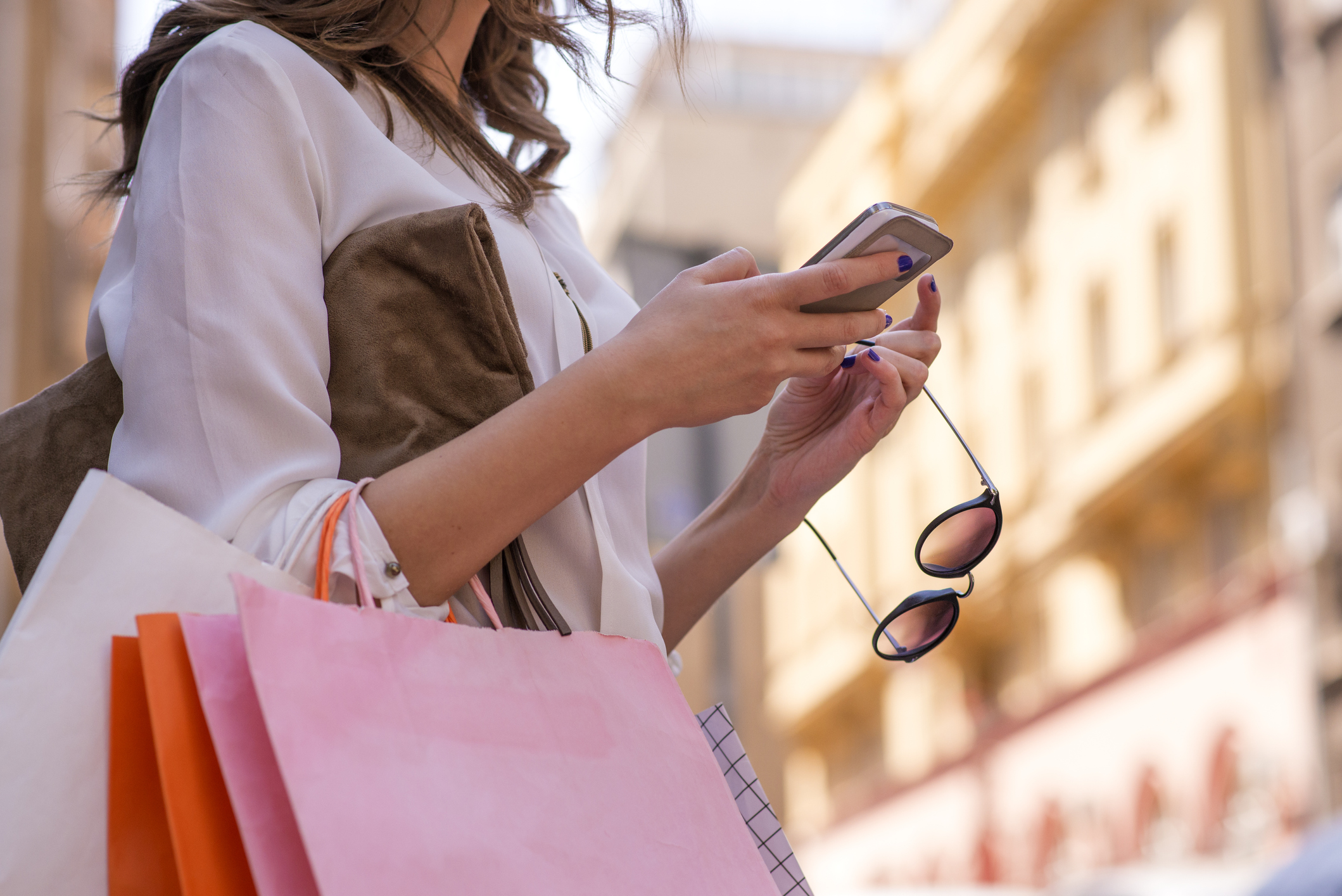 Women carrying shoppings bags and using smartphone