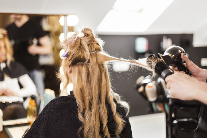 Hairdresser using hairdryer